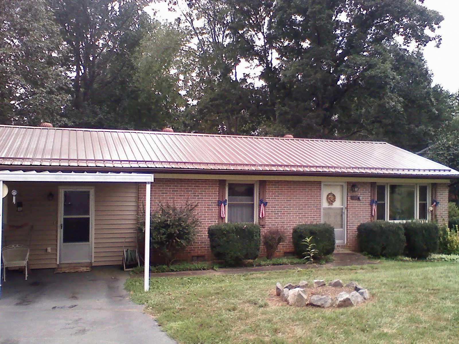 Bronze metal roof and carport on a brick ranch home — Roof Repair work by our crew in South Fulton